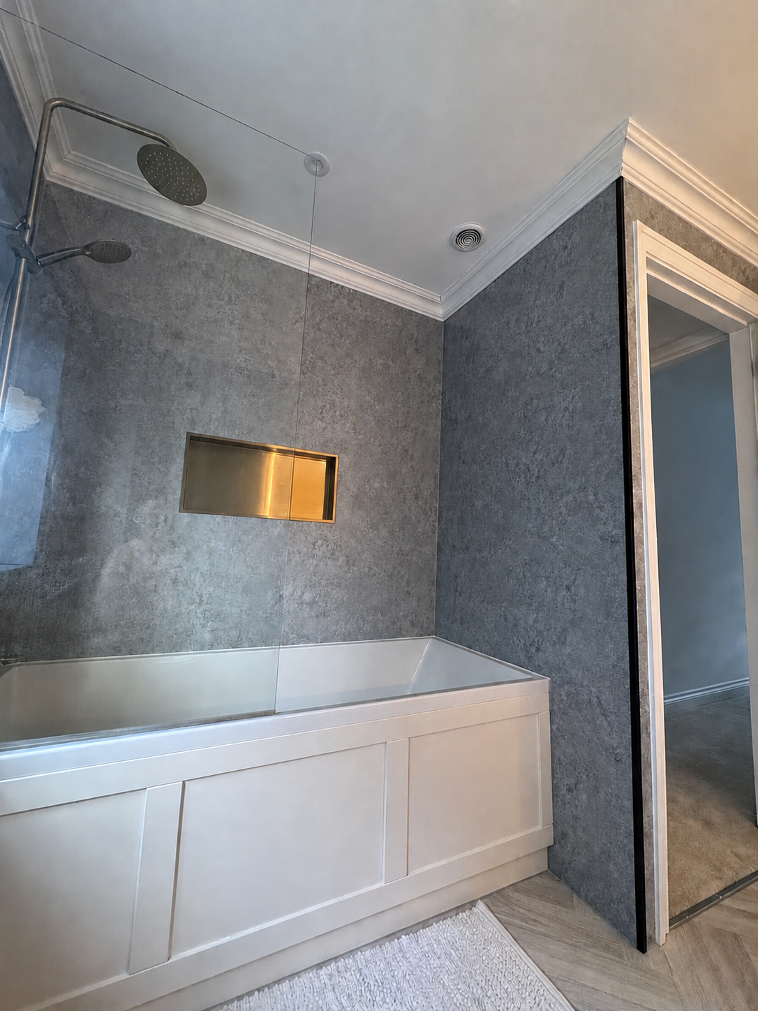 Completed bathroom with wall panels, bath and shower